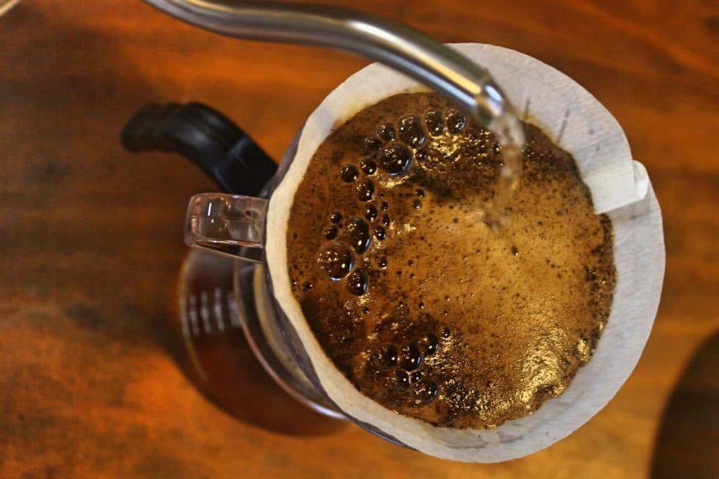 Água quente sendo despejada sobre o café no filtro de papel